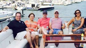Five people posing for a photo on the top deck of a charter yacht in Chicago IL