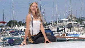 A blonde haired teen ager dressed like Tifa from Final Fantasy poses for a photo on a charter yacht