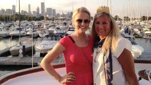 Two women on the deck of a charter yacht in Chicago IL, the background has many yachts
